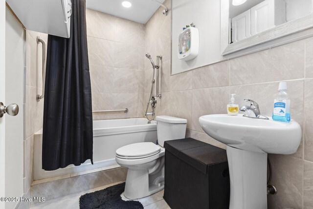 full bathroom with tile walls, tile patterned floors, shower / bath combo, and toilet