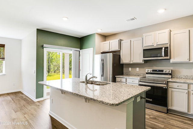 kitchen with appliances with stainless steel finishes, a wealth of natural light, a sink, and visible vents