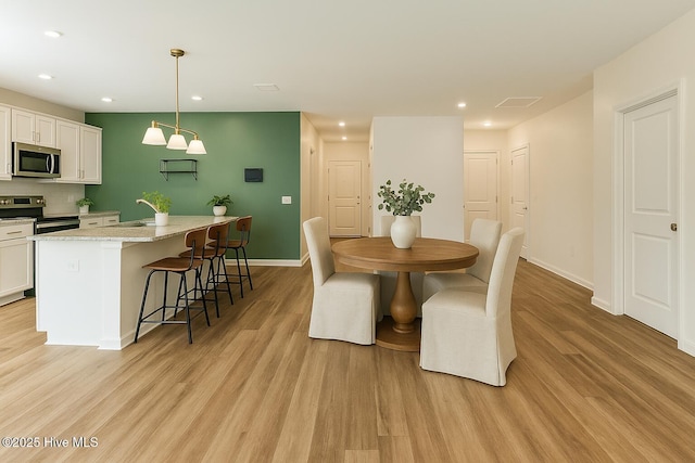 dining space featuring light wood-style floors, recessed lighting, baseboards, and visible vents