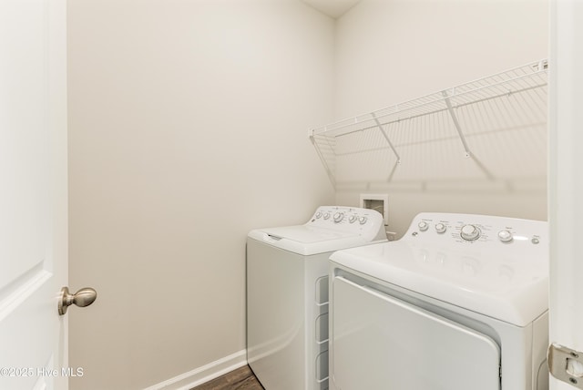 clothes washing area with separate washer and dryer, baseboards, and laundry area