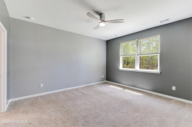 carpeted empty room featuring a ceiling fan, baseboards, and visible vents