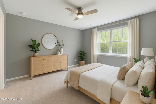 bedroom with baseboards, ceiling fan, and light carpet