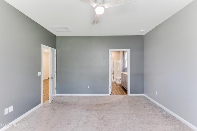 unfurnished bedroom with baseboards, ceiling fan, carpet flooring, and ensuite bath