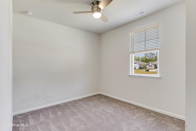 carpeted empty room with visible vents, baseboards, and ceiling fan
