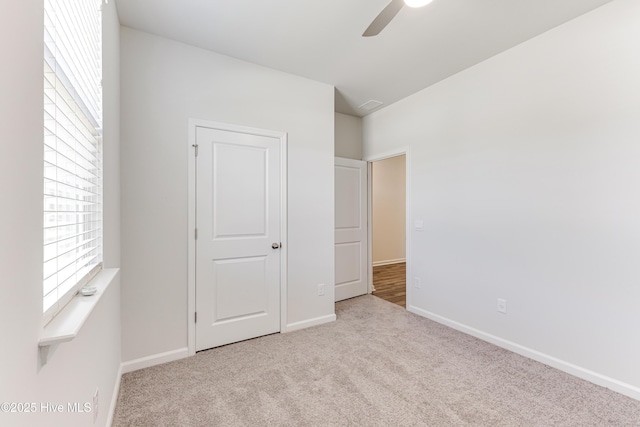 unfurnished bedroom featuring baseboards, carpet, and a ceiling fan