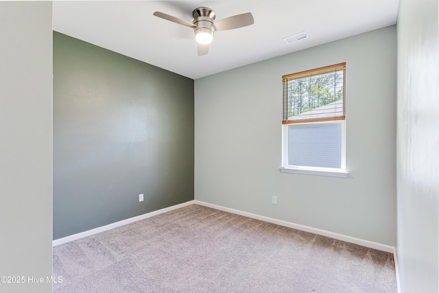 spare room featuring carpet floors, ceiling fan, visible vents, and baseboards