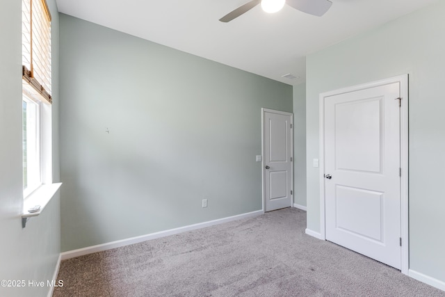 unfurnished bedroom with carpet floors, baseboards, a ceiling fan, and visible vents