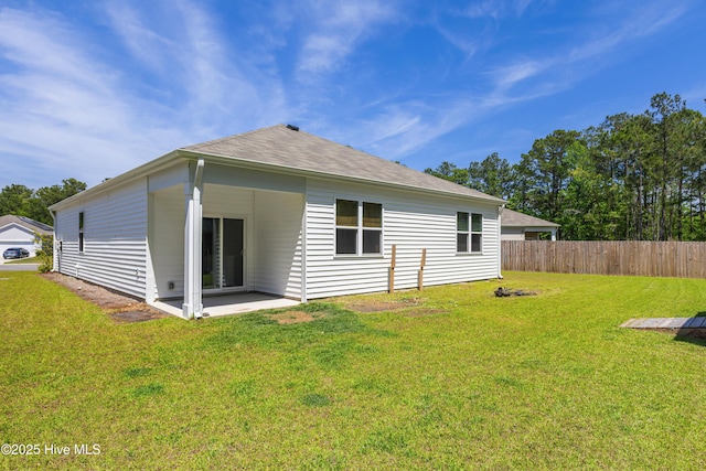 back of house with a yard, a patio, fence, and roof with shingles