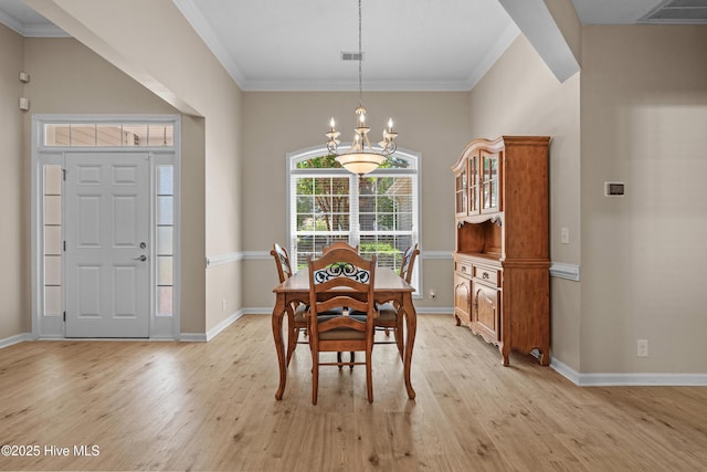 dining area with visible vents, baseboards, a chandelier, ornamental molding, and light wood-style flooring