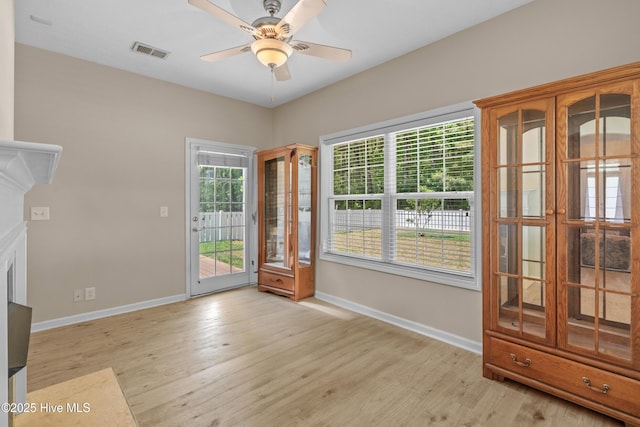 doorway to outside with a ceiling fan, baseboards, visible vents, and light wood-type flooring