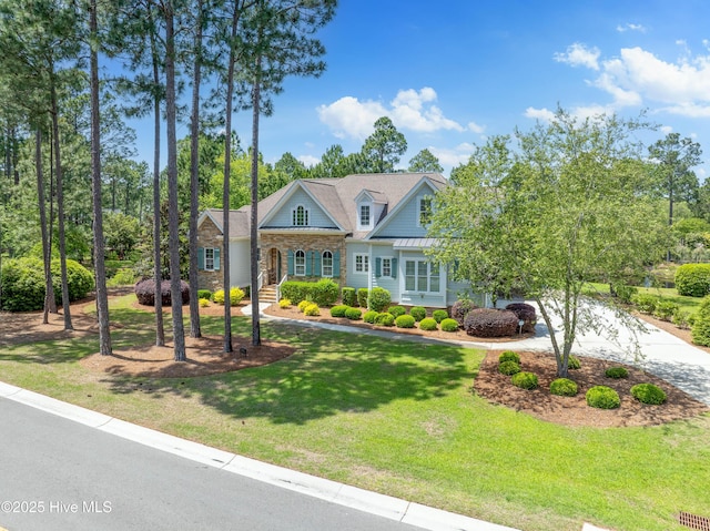 view of front of house with stone siding, a front lawn, and driveway