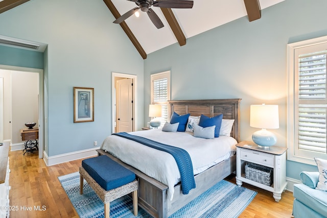 bedroom featuring beam ceiling, wood finished floors, baseboards, high vaulted ceiling, and a ceiling fan