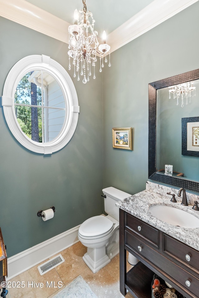 half bathroom with a chandelier, toilet, vanity, ornamental molding, and baseboards
