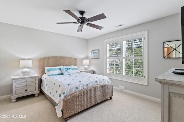 bedroom with light colored carpet, baseboards, and a ceiling fan