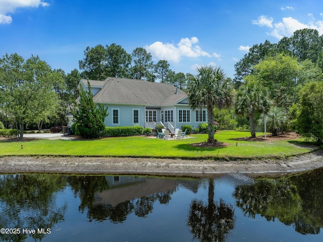 back of house featuring a lawn and a water view