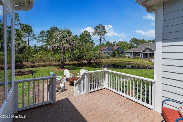 wooden deck with a water view and a yard
