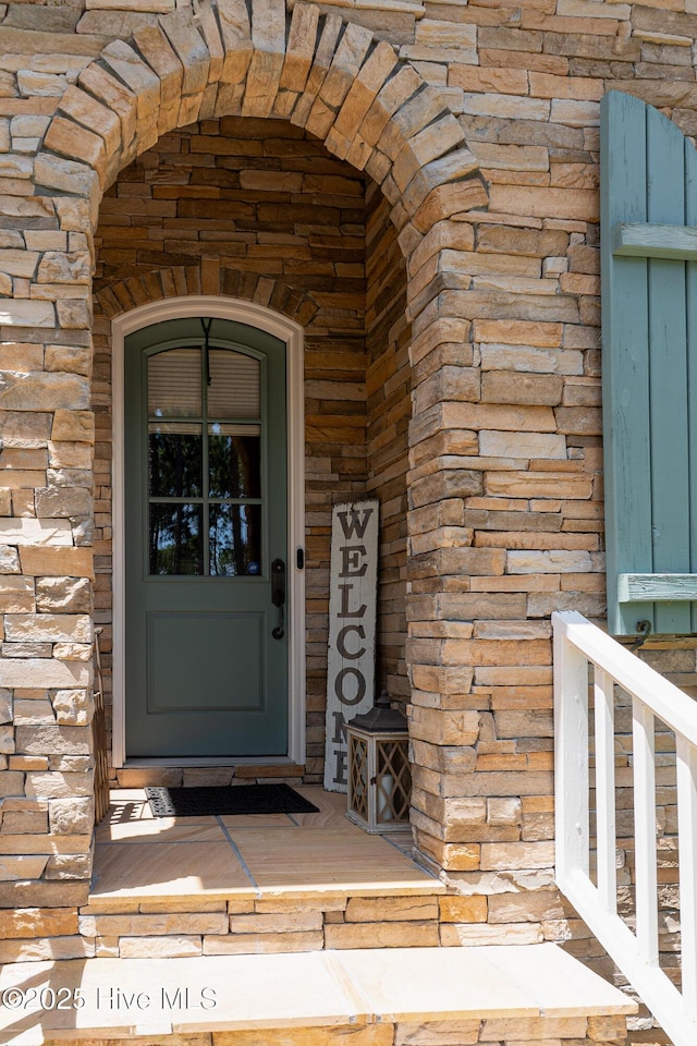 property entrance featuring stone siding