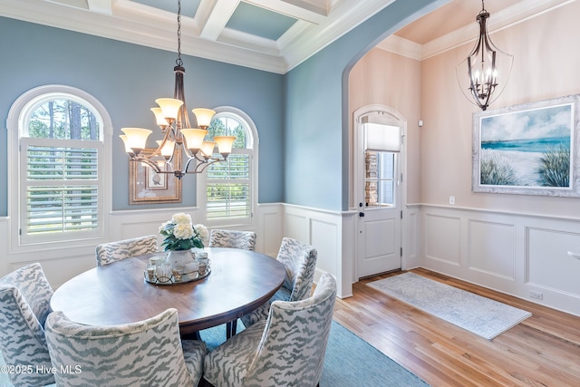 dining room with a chandelier, plenty of natural light, crown molding, arched walkways, and beam ceiling