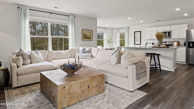 living room featuring recessed lighting, dark wood finished floors, and visible vents