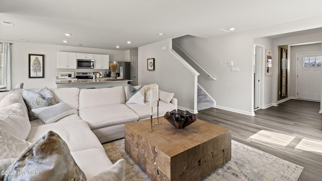living room with visible vents, wood finished floors, stairway, baseboards, and recessed lighting