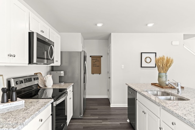 kitchen with baseboards, dark wood-type flooring, white cabinets, a sink, and appliances with stainless steel finishes