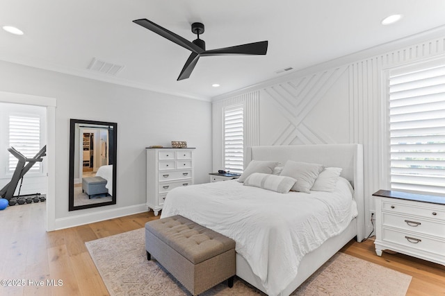 bedroom featuring crown molding, visible vents, and light wood-style flooring