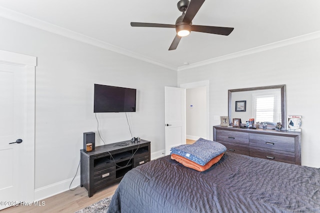 bedroom with light wood-style floors, baseboards, ornamental molding, and a ceiling fan