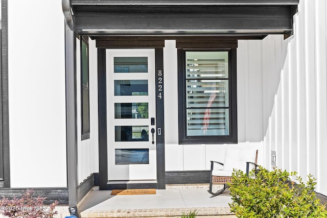 entrance to property featuring board and batten siding and covered porch