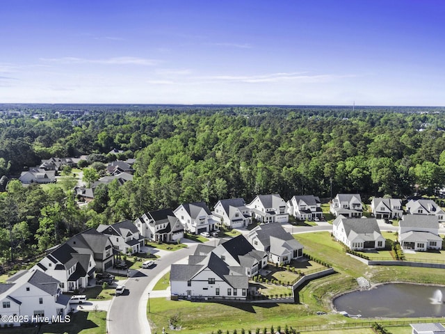 birds eye view of property featuring a forest view, a water view, and a residential view