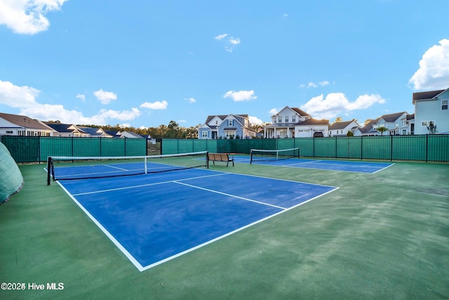 view of sport court with fence and a residential view