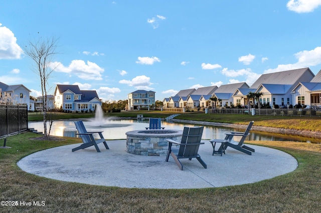 view of patio / terrace with a water view, a fire pit, and a residential view