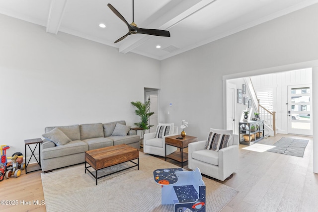 living area with a ceiling fan, visible vents, beam ceiling, wood finished floors, and stairs