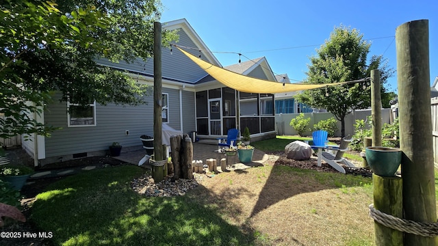 rear view of property with fence, a yard, a sunroom, and crawl space