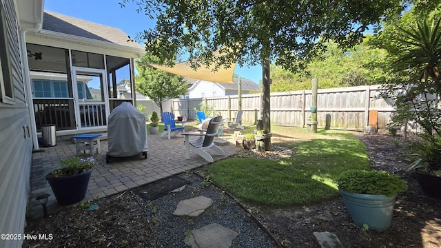 view of yard featuring a fenced backyard, a patio, and a sunroom