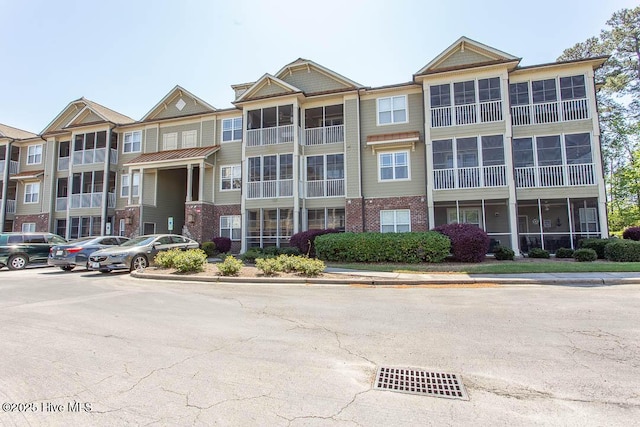 view of apartment building / complex featuring uncovered parking