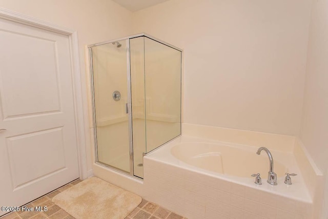bathroom with a stall shower and a garden tub