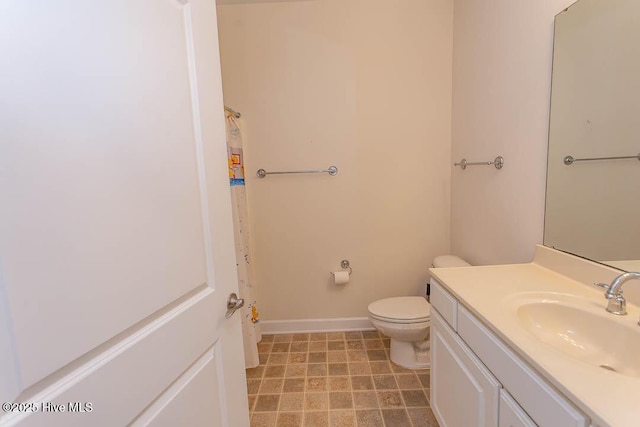bathroom featuring toilet, vanity, baseboards, and curtained shower