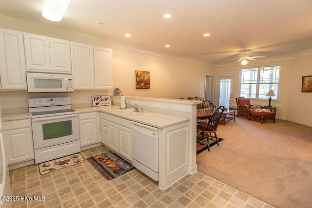 kitchen featuring white appliances, a peninsula, crown molding, white cabinets, and light countertops