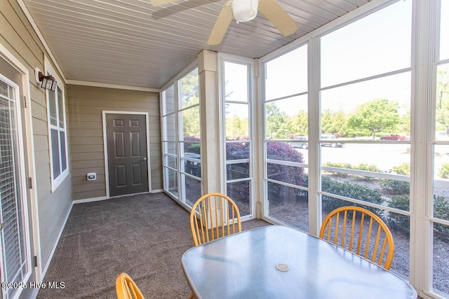 sunroom / solarium featuring a ceiling fan and outdoor dining space