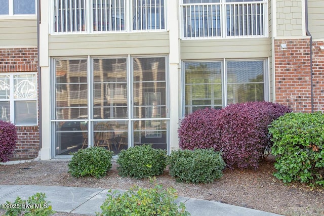 doorway to property with brick siding