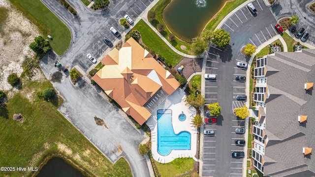 drone / aerial view of a pool and a large body of water