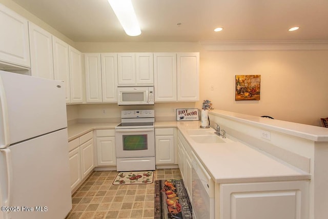 kitchen with white appliances, a sink, a peninsula, white cabinetry, and recessed lighting