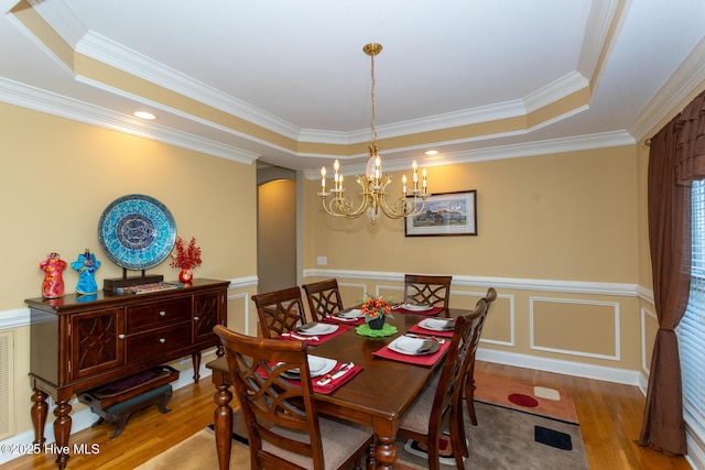 84 Deerwood Ln, Pinehurst, NC 28374 - dining room featuring crown molding, arched walkways, wood finished floors, a raised ceiling, and a notable chandelier