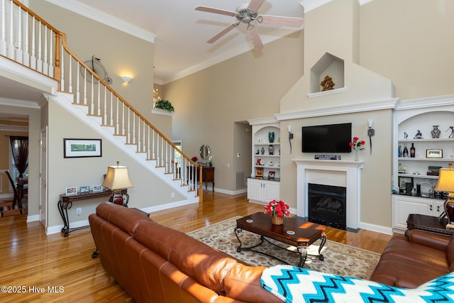 84 Deerwood Ln, Pinehurst, NC 28374 - living area featuring a towering ceiling, stairs, a ceiling fan, light wood-type flooring, and ornamental molding