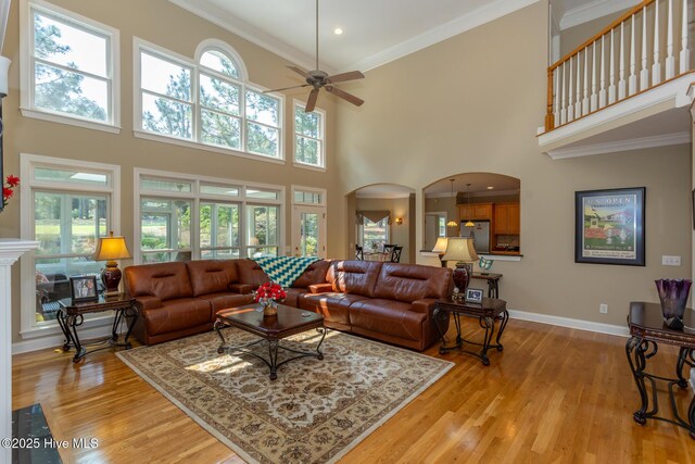 84 Deerwood Ln, Pinehurst, NC 28374 - living room with arched walkways, ceiling fan, ornamental molding, and light wood finished floors
