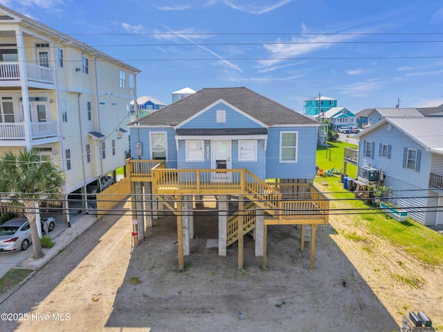 exterior space with roof with shingles, fence, stairs, and a residential view