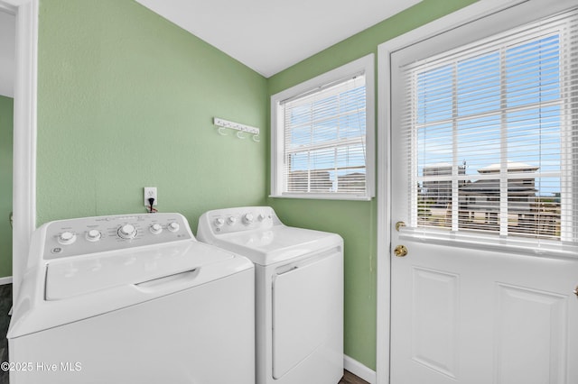 clothes washing area featuring baseboards, laundry area, and washer and dryer