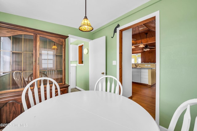 dining space featuring baseboards, a ceiling fan, and wood finished floors
