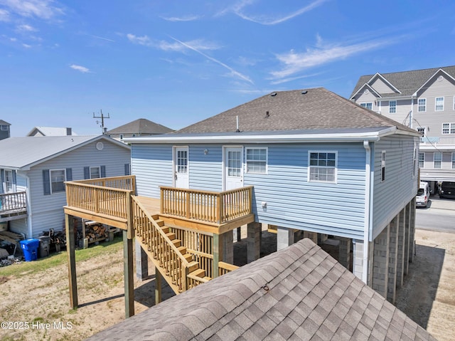 rear view of house with stairs, a shingled roof, and a deck