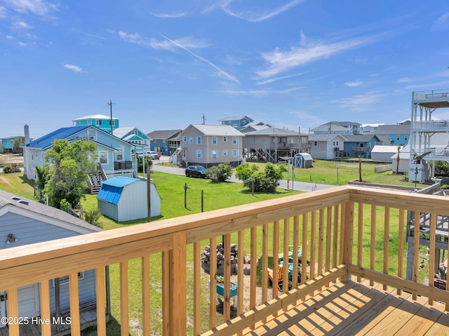 deck with a yard, a residential view, an outdoor structure, and a storage unit